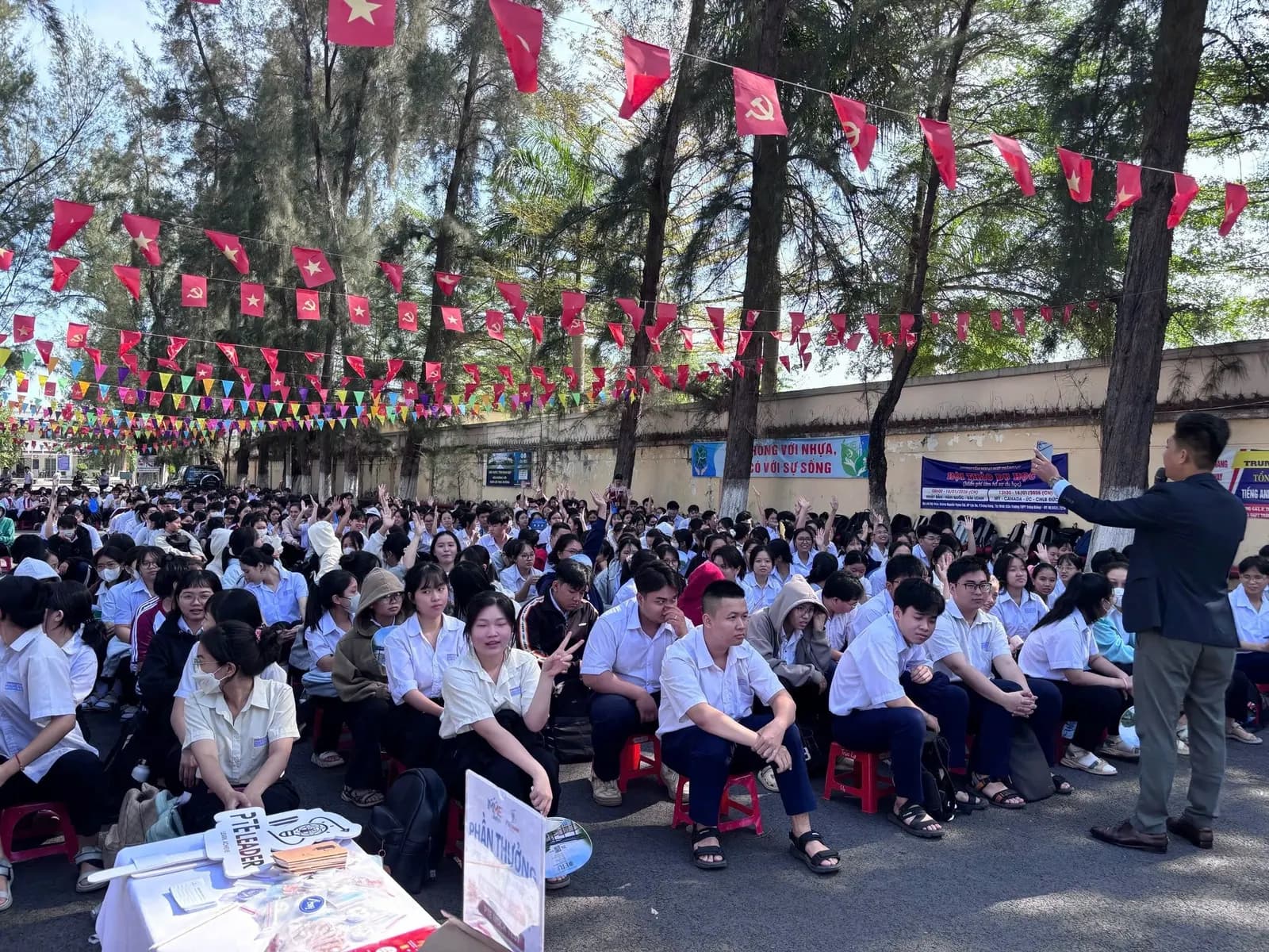 Học sinh ngồi thành hàng dưới sân trường nghe tư vấn hướng nghiệp