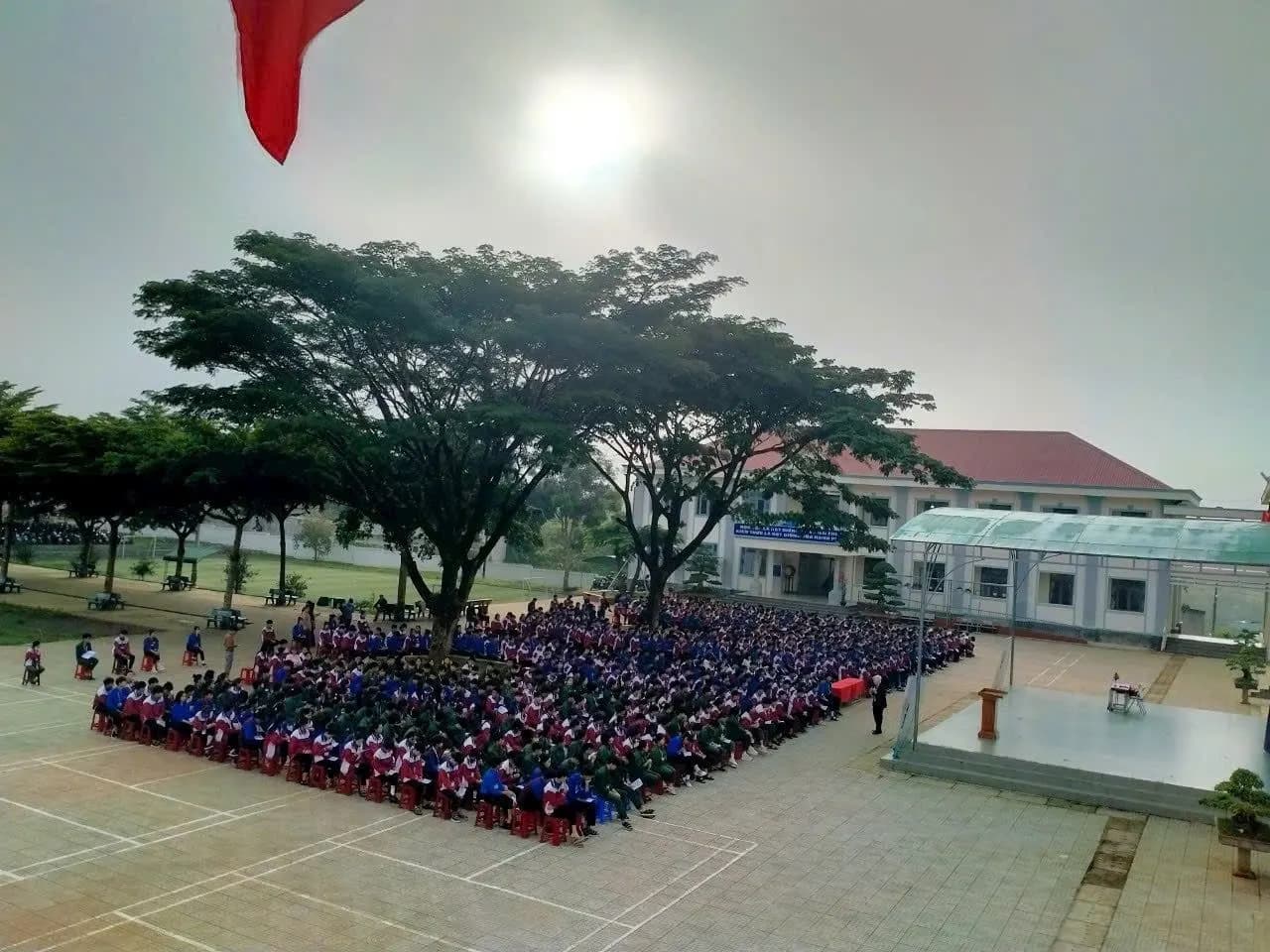 Nhìn từ trên cao: sân trường kín học sinh dưới tán cây trong nắng sớm